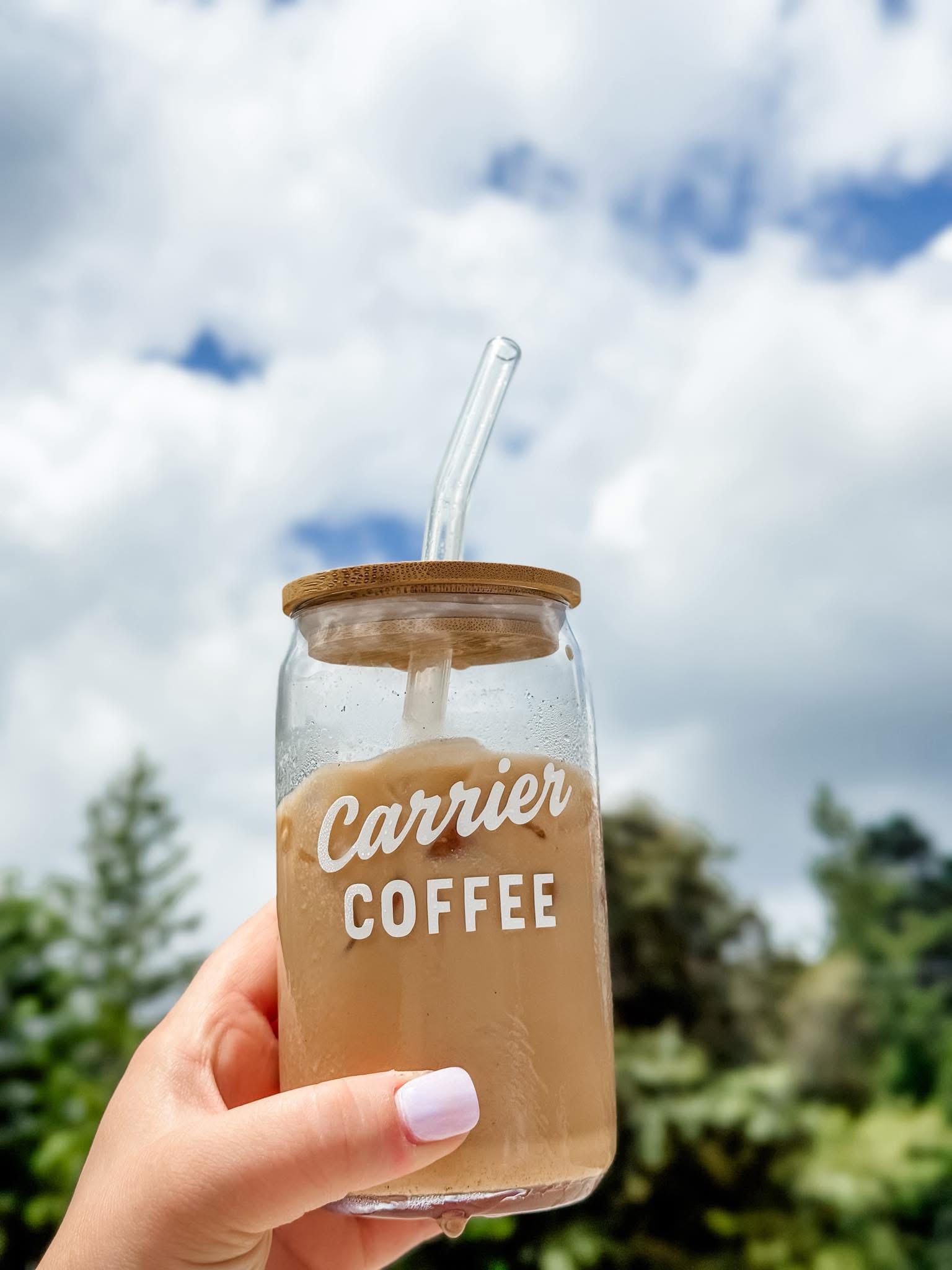 A Carrier glass cup held up to the sky